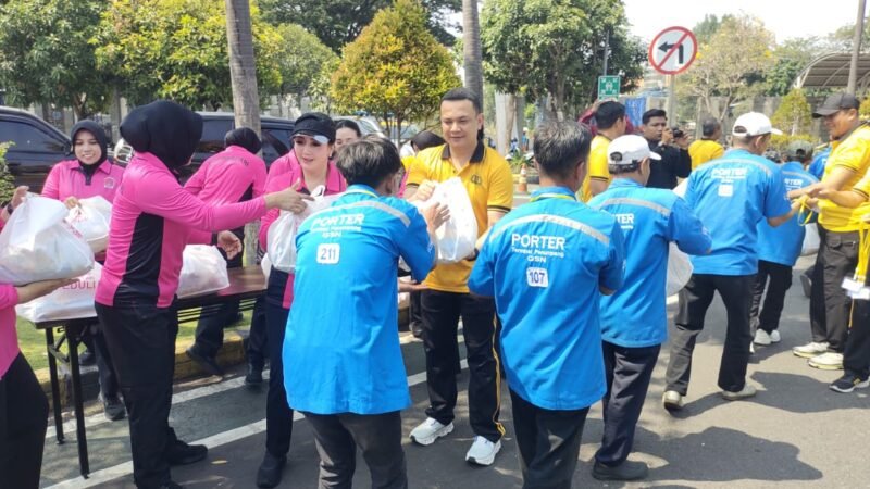 Kapolres Pelabuhan Tanjung Perak AKBP Irwan Kurniawan bersama Ketua Bhayangkari Cabang Polres Pelabuhan Tanjung Perak Ny. Tiwi Irwan menyerahkan bantuan sosial kepada para portir di Terminal Gapura Surya Nusantara, Jumat (11/9/2026).