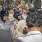 Polwan Polres Blitar Polda Jatim membagikan air minum kepada massa aksi dan membersihkan sampah bersama peserta setelah penyampaian aspirasi di depan Kantor Pemkab Blitar.