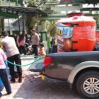 Personel Polsek Suruh, Polres Trenggalek, menyalurkan bantuan air bersih menggunakan armada Patroli Gentong ke SD Negeri 1 Suruh dan sejumlah fasilitas umum di tengah dampak kekeringan.