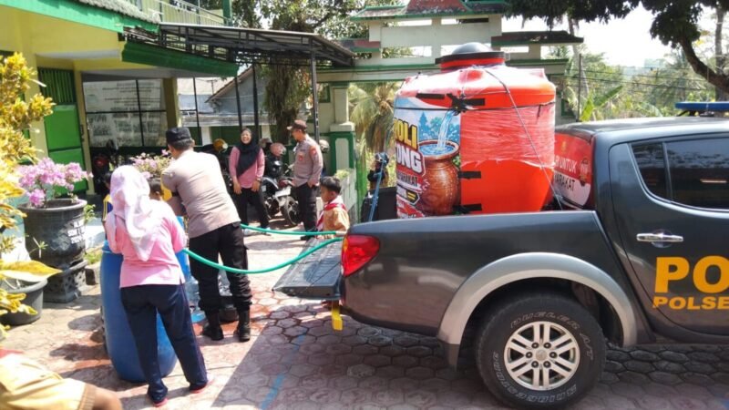 Personel Polsek Suruh, Polres Trenggalek, menyalurkan bantuan air bersih menggunakan armada Patroli Gentong ke SD Negeri 1 Suruh dan sejumlah fasilitas umum di tengah dampak kekeringan.