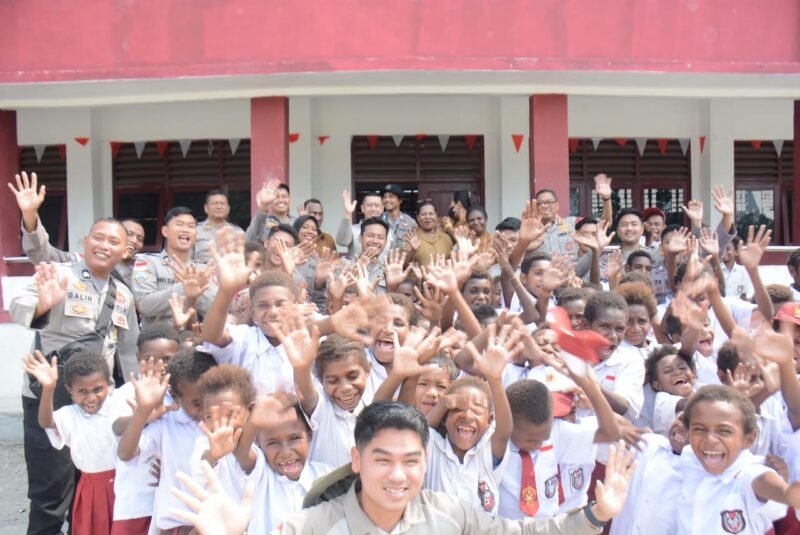 Personel Satgas Operasi Damai Cartenz-2026 menyerahkan tas dan perlengkapan belajar kepada siswa sekolah dasar di wilayah Pomako, Kabupaten Mimika, Papua Tengah, Kamis (1/10/2026).