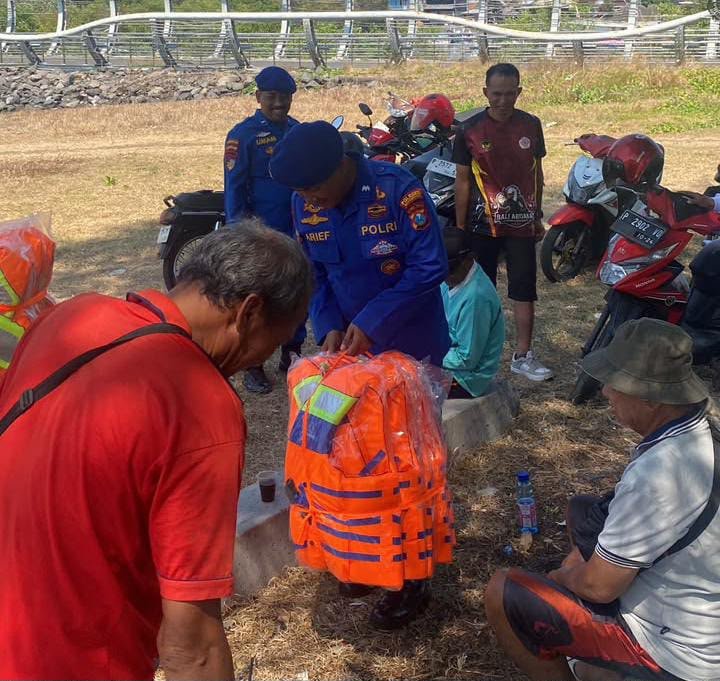 Personel Satpolairud Polresta Banyuwangi membagikan life jacket kepada kelompok nelayan KUB Pulau Wangi di Pantai Marina Boom, Banyuwangi.