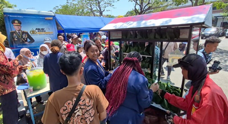 Kapolsek Gubeng AKP Sugarda Aditya Buwana Trenggoro bersama anggota dan mahasiswa komunitas Orang Asli Papua (OAP) membagikan makanan gratis melalui Gerobak JUPE di Lapangan B Polrestabes Surabaya.