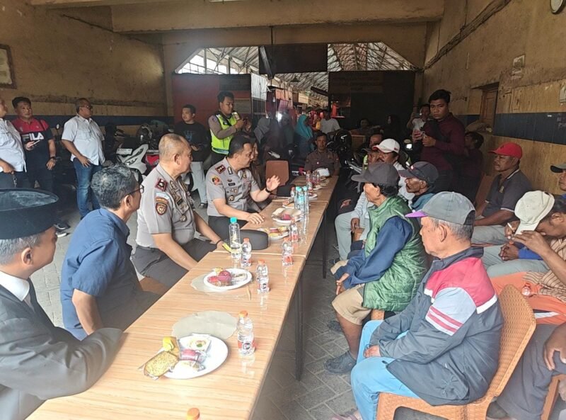 Kapolres Pelabuhan Tanjung Perak AKBP Irwan Kurniawan berdialog bersama kuli panggul, juru parkir, dan pedagang dalam kegiatan cangkrukan kamtibmas di Pasar Pabean Cantian, Surabaya, Rabu (28/10/2026).